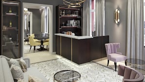 Una sala de estar moderna con un sofá, sillones, una mesa de centro, un televisor y una estantería.