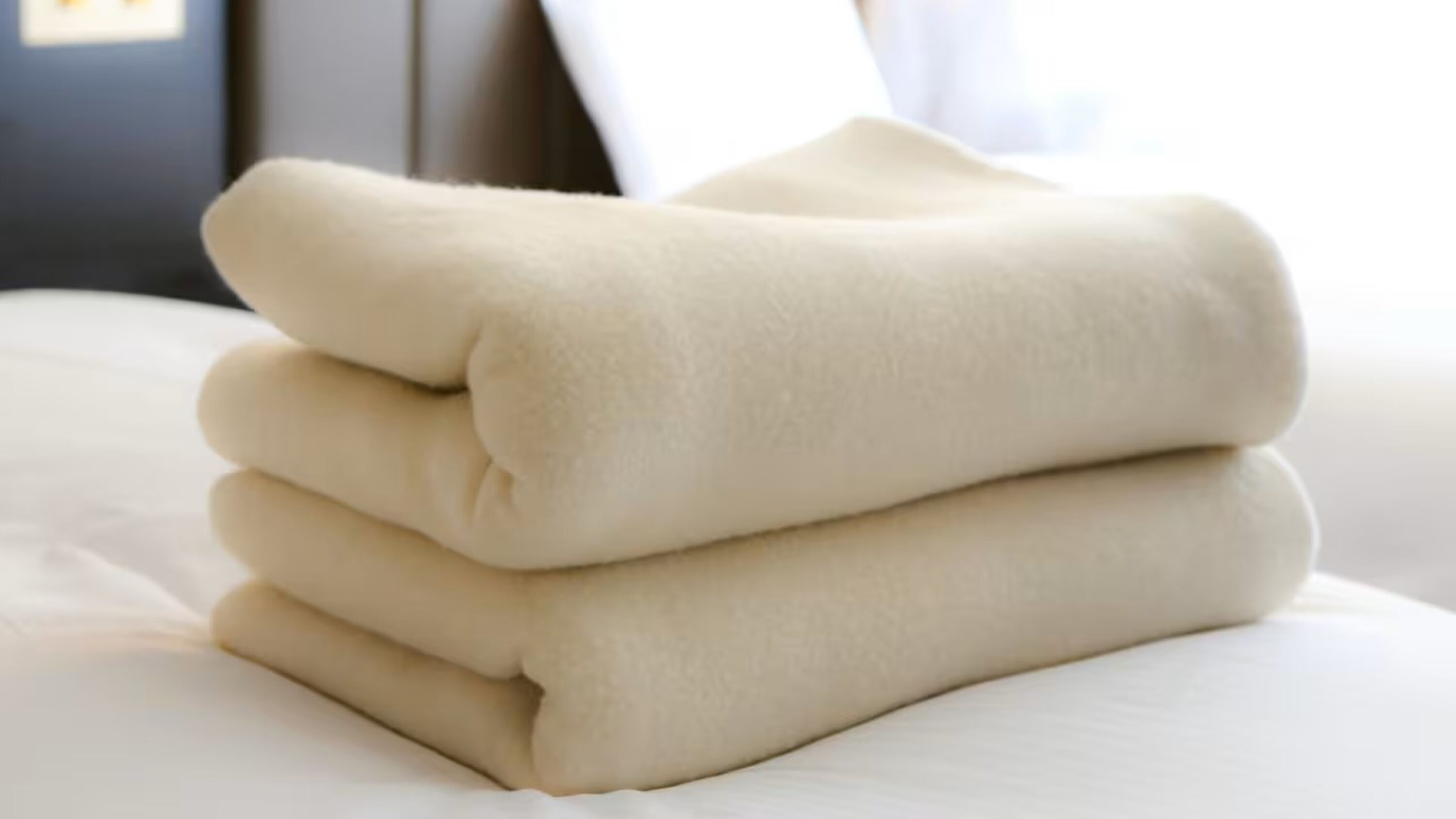 Une pile de serviettes pliées sur un lit.