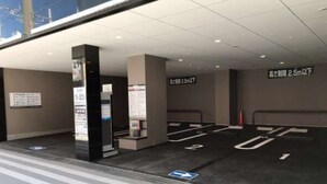 Un estacionamiento con señalización clara que indica restricciones de altura y flechas direccionales para el flujo del tráfico.