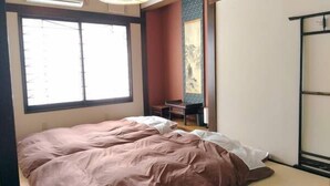 A bedroom with a large window, a bed, a desk, and a wardrobe. - Guest House Kuranomachi - Hostel (Tochigi)