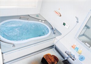 A bathroom with a bathtub, a shower, and a sink. - Guesthouse Chaconne Karuizawa (Karuizawa)