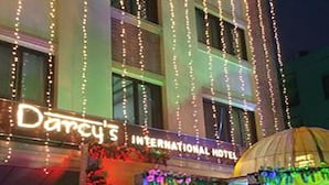 Exterior del Hotel International con luces colgantes y una decoración de árbol de Navidad.