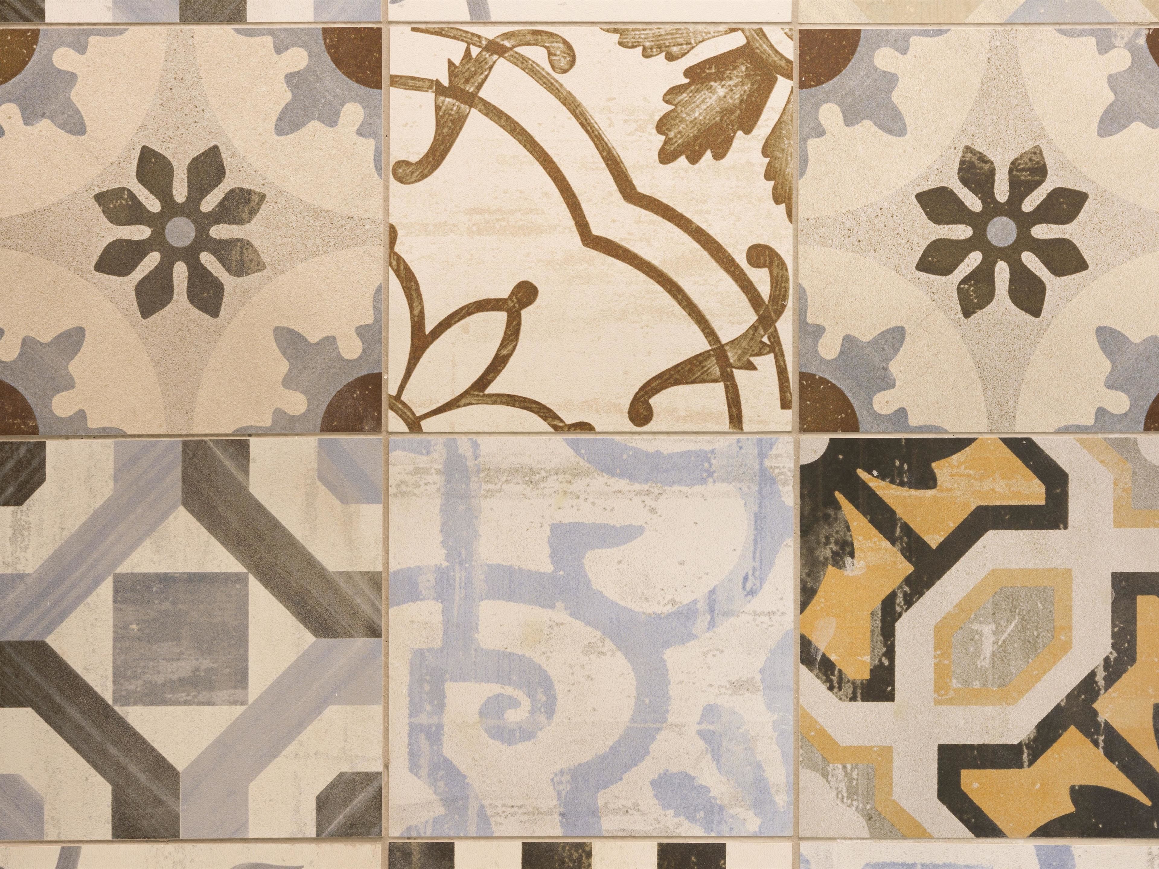A tiled wall with various geometric and floral patterns.