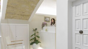 A reception area with a white reception desk, a potted plant, and a framed picture on the wall. - Townhouse Tropea (Tropea)