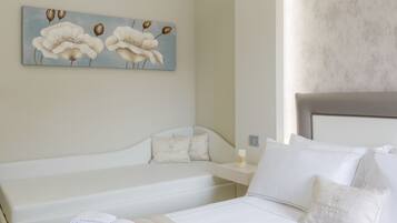 Una habitación de hotel con una cama, una mesita de noche y un cuadro de flores en la pared.