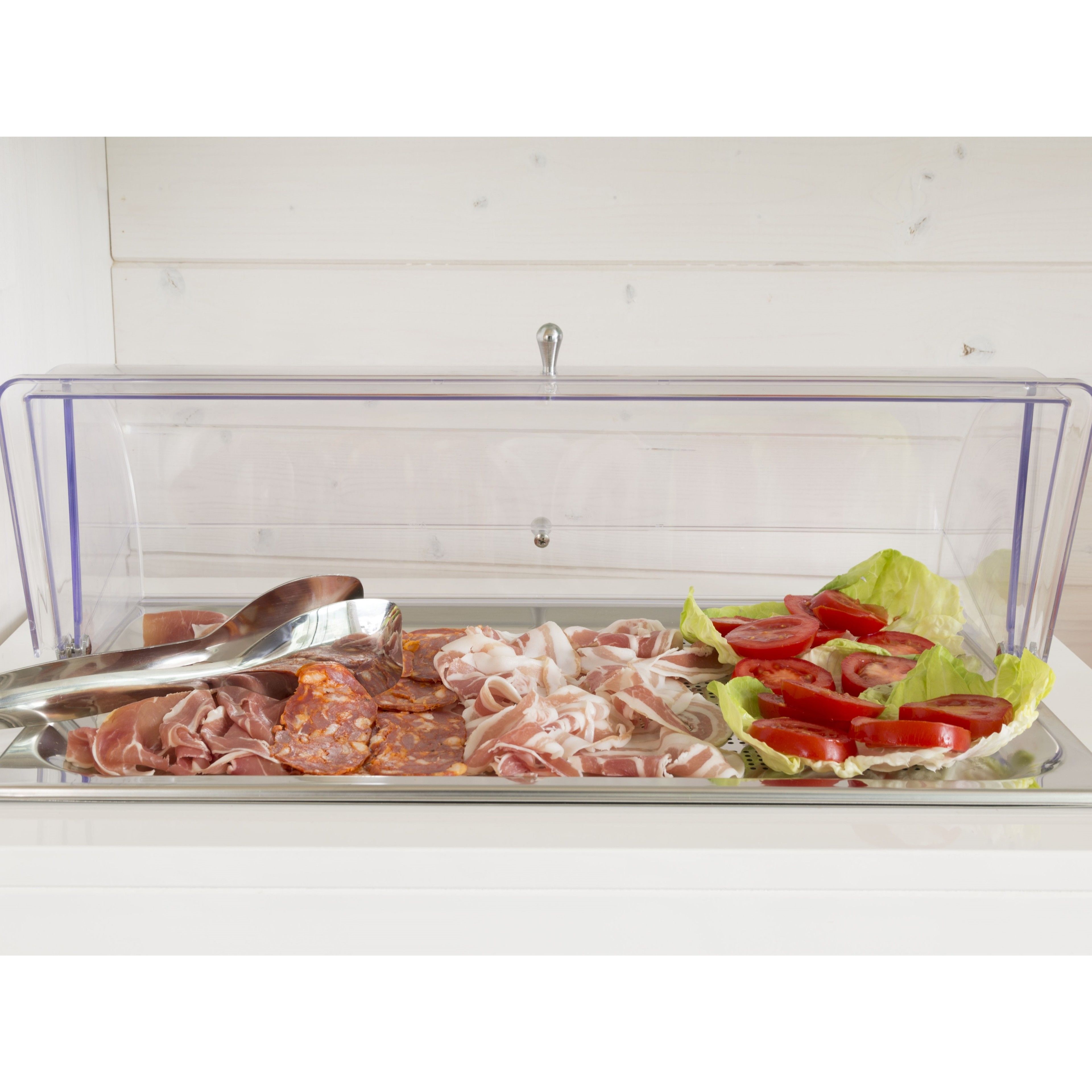 Un recipiente de plástico transparente con tapa de metal, que contiene carnes en lonchas y verduras frescas.