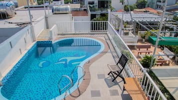 Una piscina al aire libre, sillones reclinables de piscina