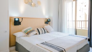 Un lit bien fait, avec une tête de lit en bois, deux lampes fixées au mur et un élément décoratif mural.