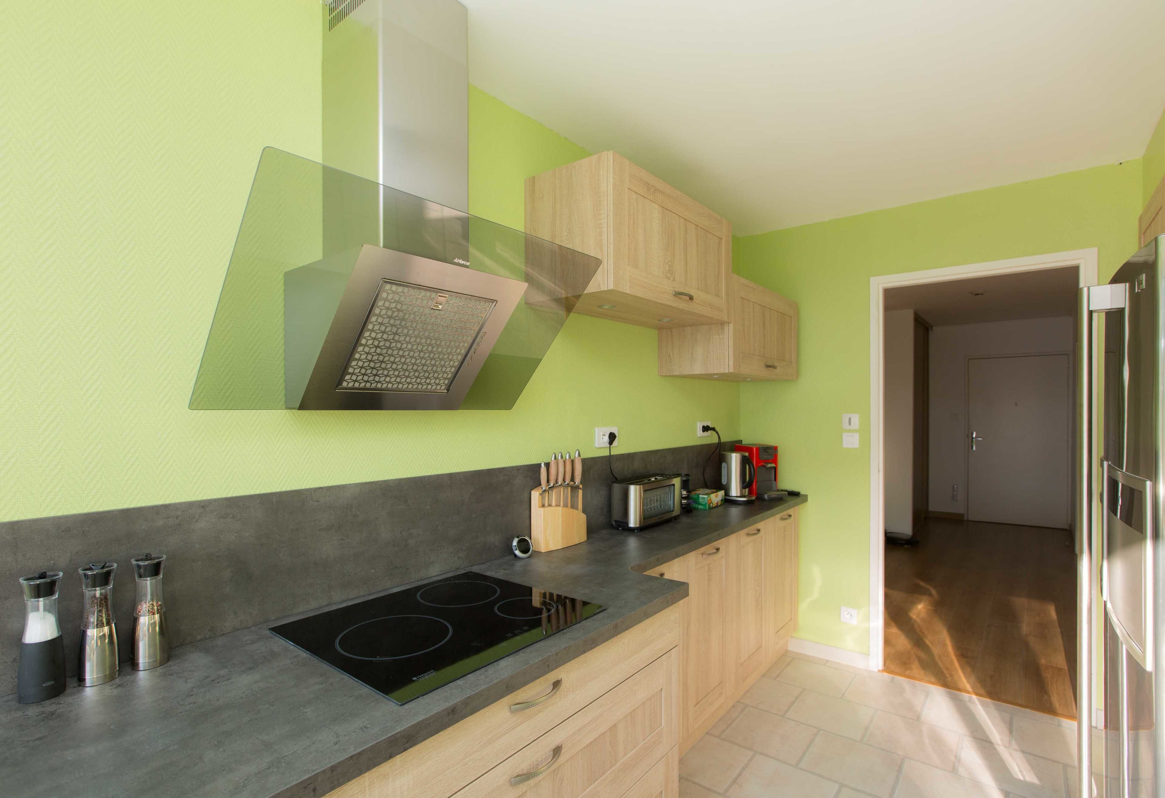 A kitchen with a black stovetop, wooden cabinets, a microwave, and a coffee maker.