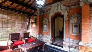 A traditional room with wooden furniture, a checkered floor, and ornate architectural details. - Ganesha Ubud Inn (Ubud)