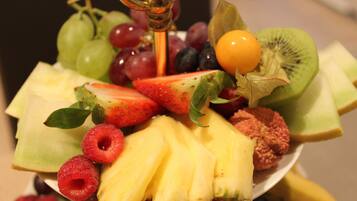 Eine Obstplatte mit verschiedenen Früchten, darunter Trauben, Erdbeeren, Kiwis, Ananas und Himbeeren.