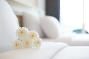 A white sofa with a bouquet of white flowers placed on it.