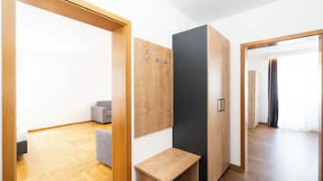 Un interno moderno con parquet, una panca e un armadio con pannello nero.