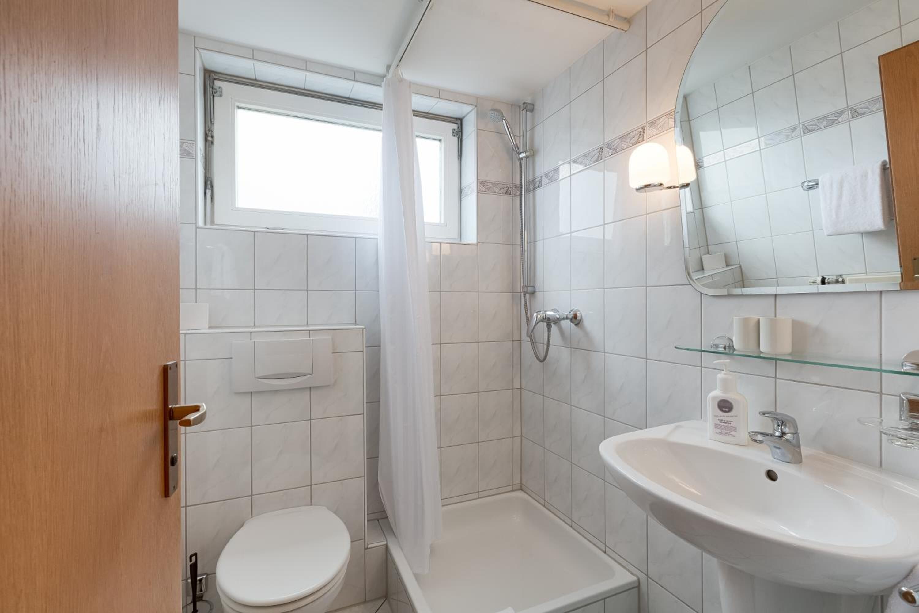 Ein modernes Badezimmer mit Toilette, Dusche und Waschbecken.