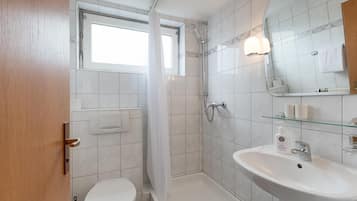 Ein modernes Badezimmer mit Toilette, Dusche und Waschbecken.