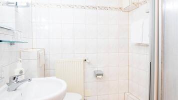 A bathroom with a sink, toilet, and shower.