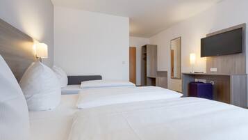 Een hotelkamer met een groot bed, een flatscreen televisie aan de wand en een houten hoofdeinde.