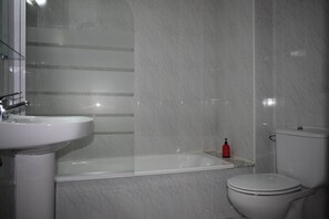 Une salle de bain avec une baignoire, un lavabo et des toilettes.