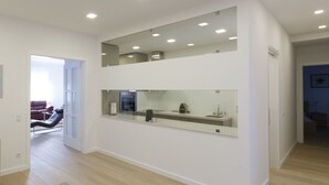 Un espacio habitable moderno y de concepto abierto con cocina, comedor y zona de estar con sofá y sillones.