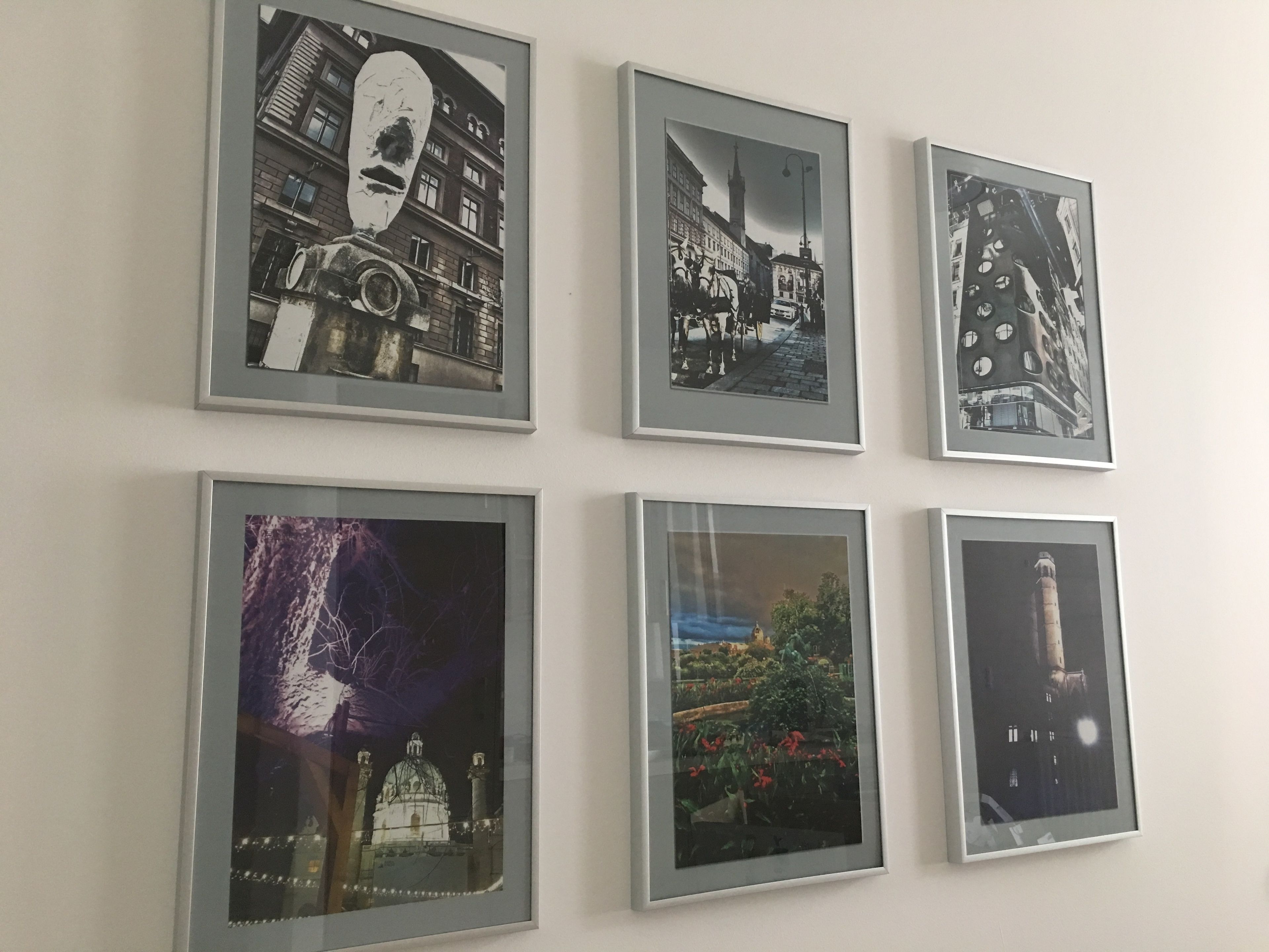 Sechs gerahmte Fotografien an einer Wand, die verschiedene Szenen zeigen.