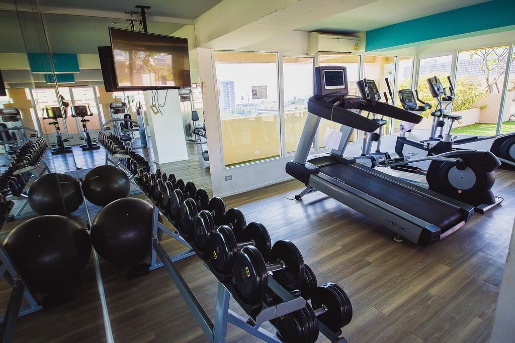 A gym with treadmills, weight machines, and free weights.