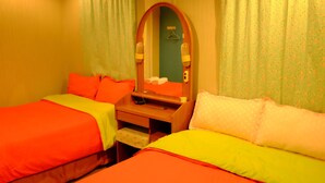 A hotel room with two beds, a wooden nightstand, a mirror, and a small table. - Kaikatak Resort (Klaeng)