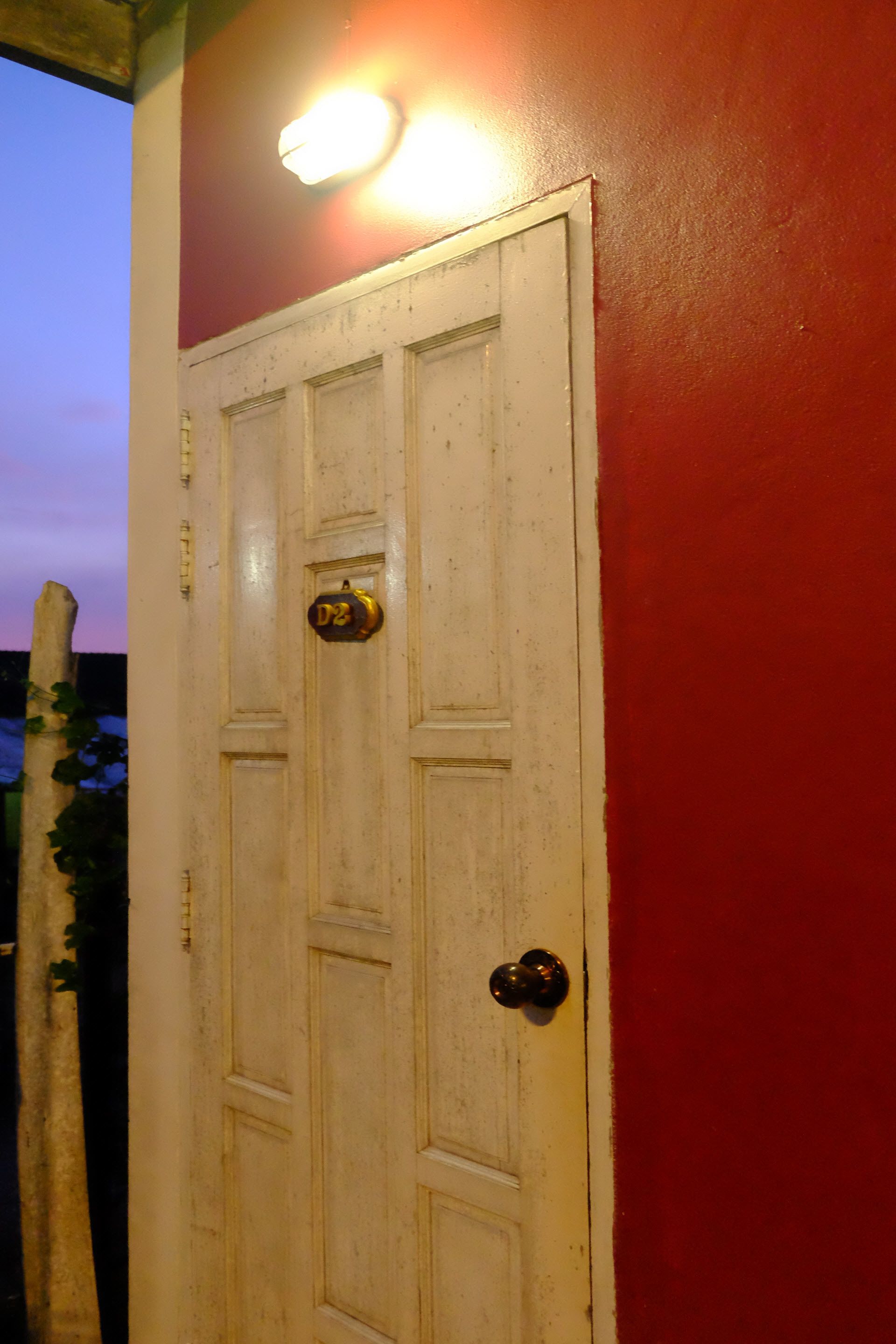 A white door with a brass doorknob and a brass plate with the number "D3".