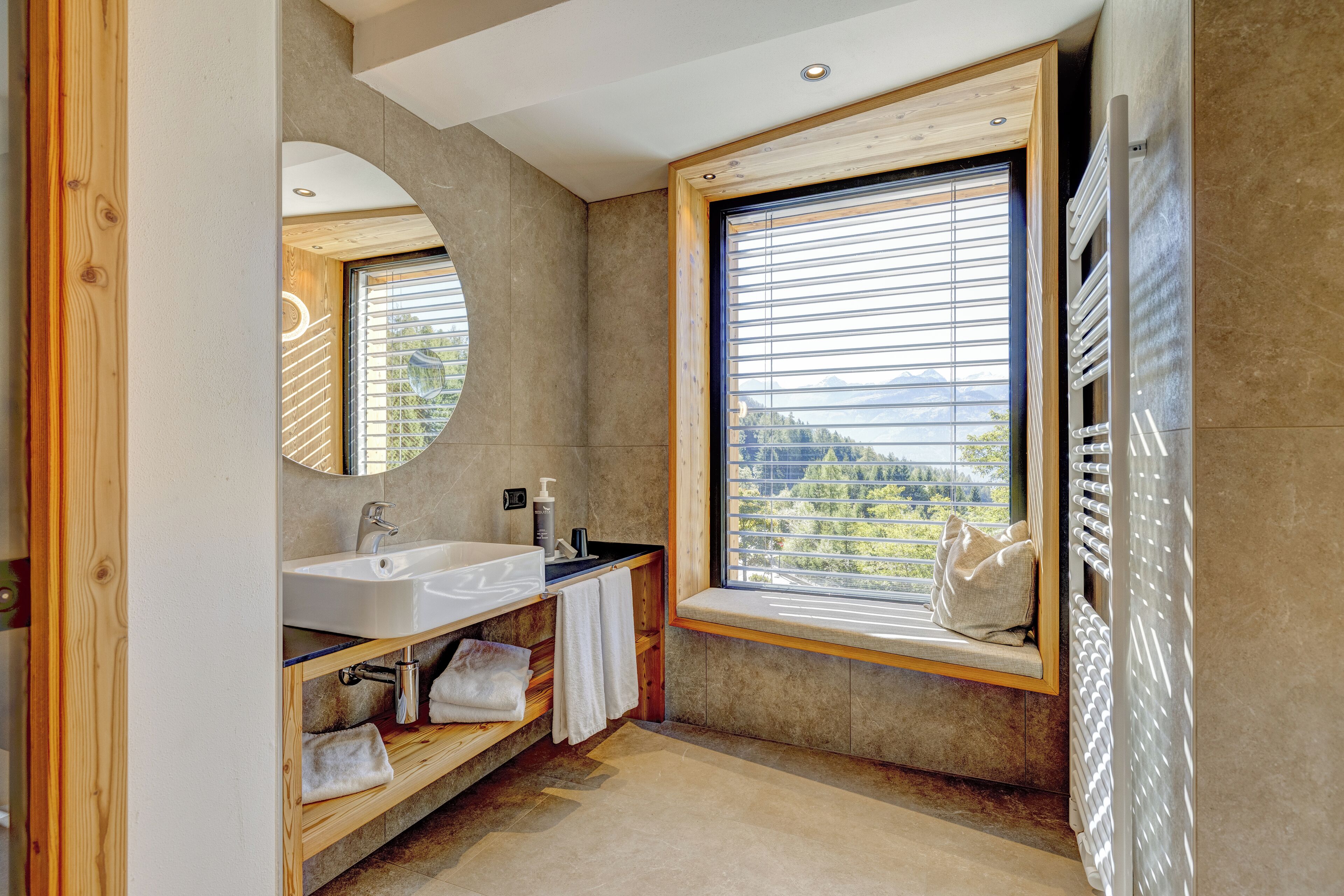 Un bagno moderno con un'ampia finestra, un lavandino integrato e un portasciugamani.