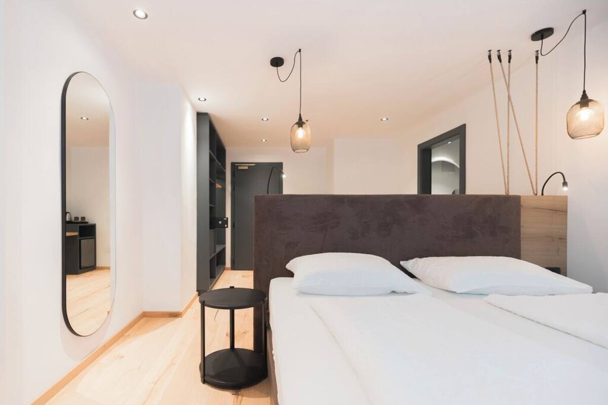 Superior driepersoonskamer | Een kluis op de kamer, een bureau, verduisterende gordijnen