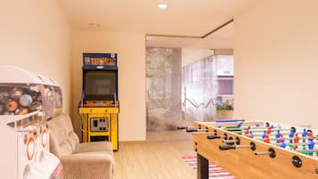 Relax in this stylish room with a foosball table, TV, and plant.