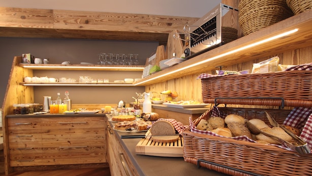 Un buffet de petit-déjeuner proposant un assortiment de pains, de viennoiseries et de boissons.
