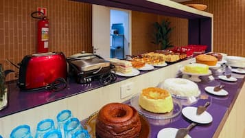 A buffet with various food items, a toaster, a coffee maker, and a fire extinguisher.