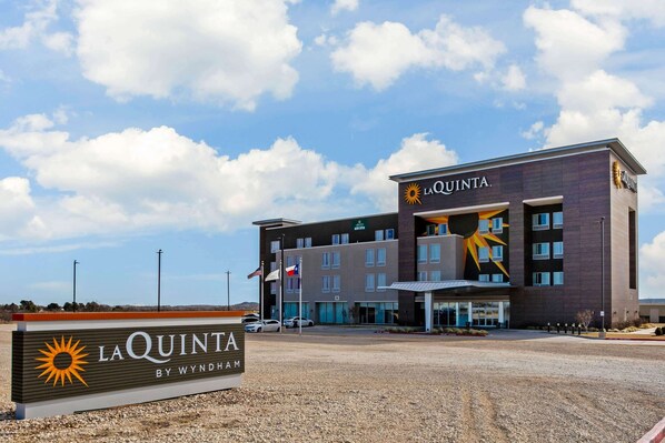Un hôtel appelé La Quinta by Wyndham, doté d’un design moderne, d’un parking et offrant une vue sur un ciel dégagé.