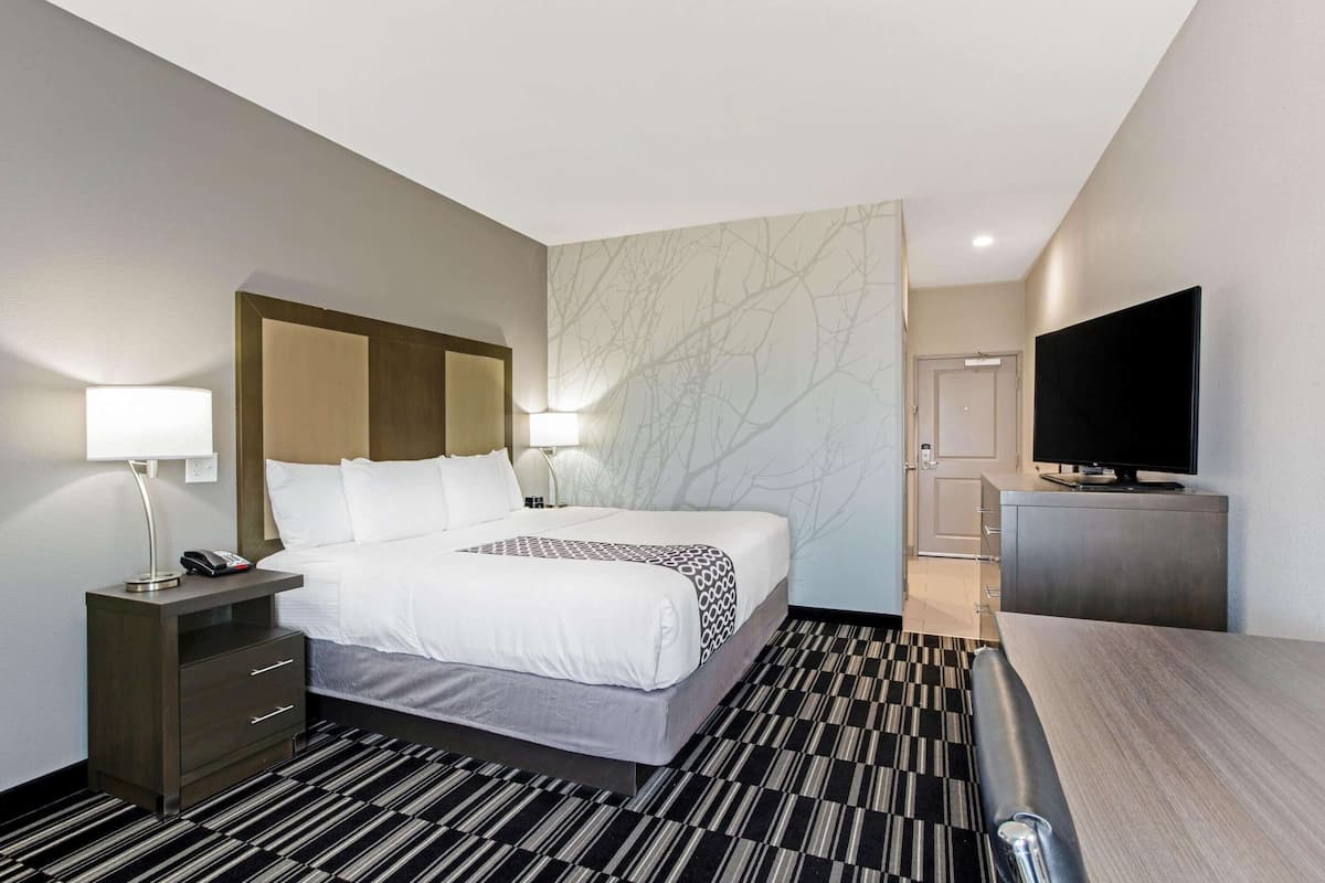 Ein Hotelzimmer mit Bett, Nachttischen, Fernseher und Schreibtisch.