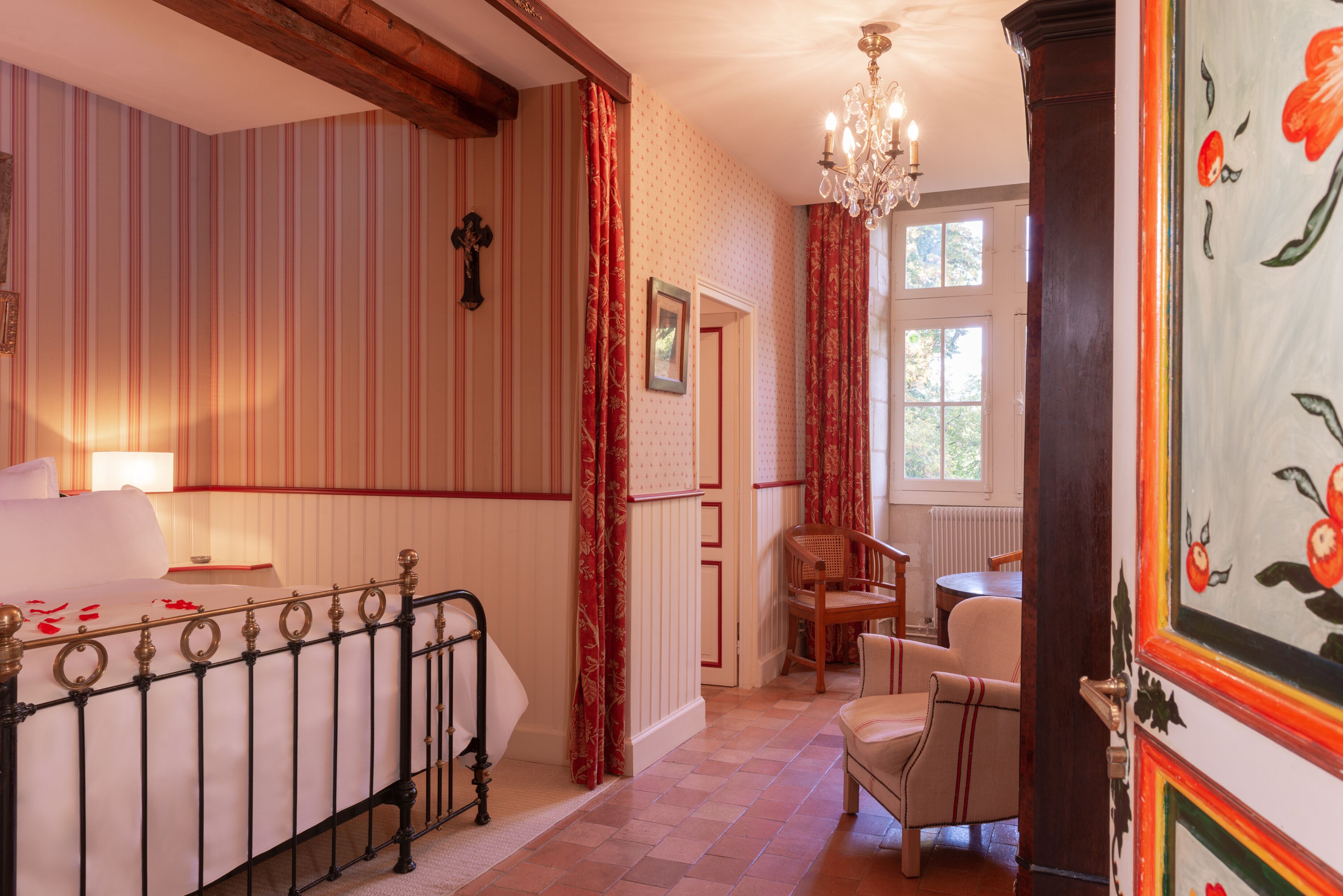 Une chambre à coucher avec un lit, une chaise, une table et une fenêtre.