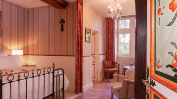 Une chambre à coucher avec un lit, une chaise, une table et une fenêtre.