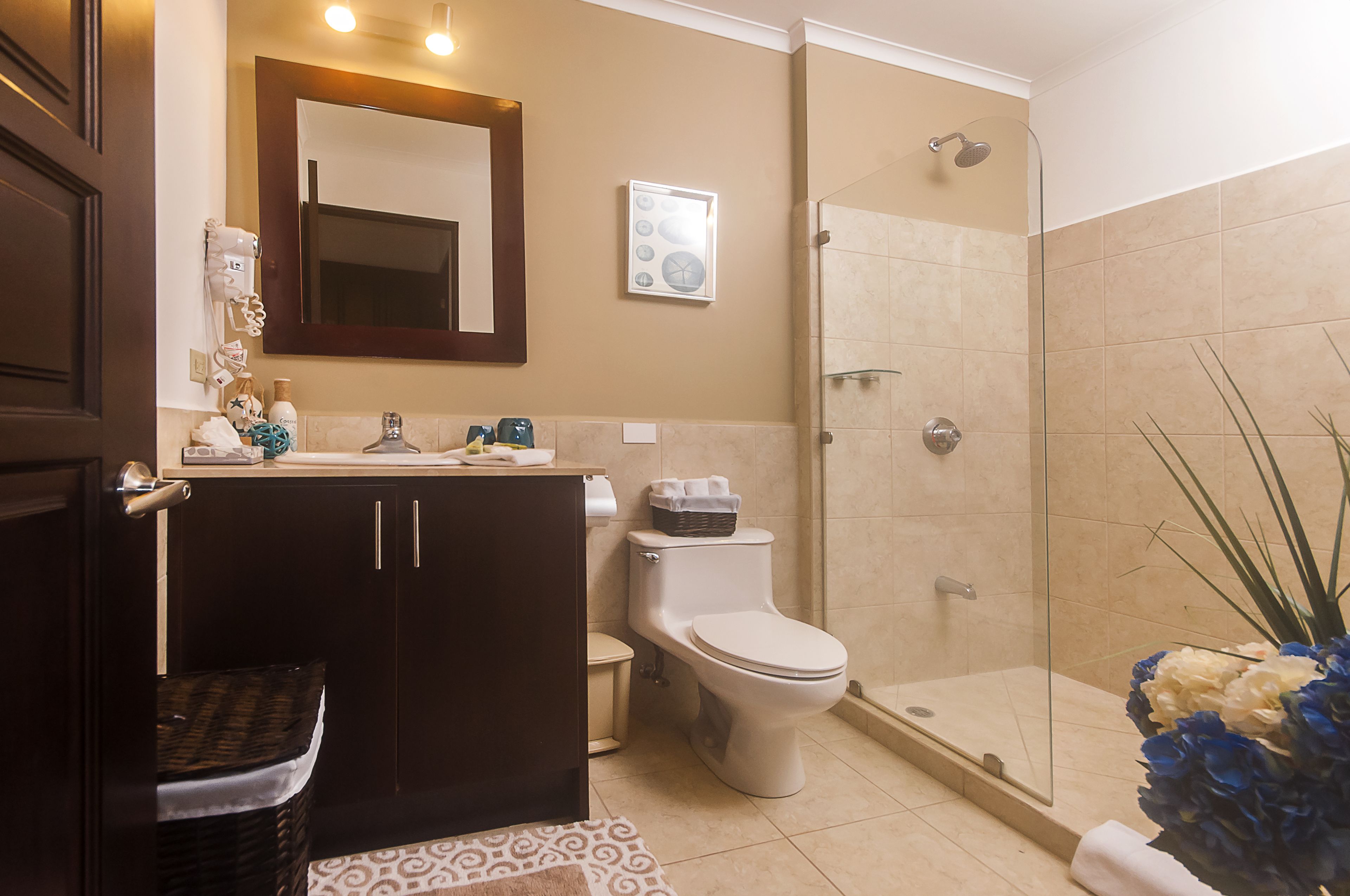 A bathroom with a toilet, sink, and shower area.