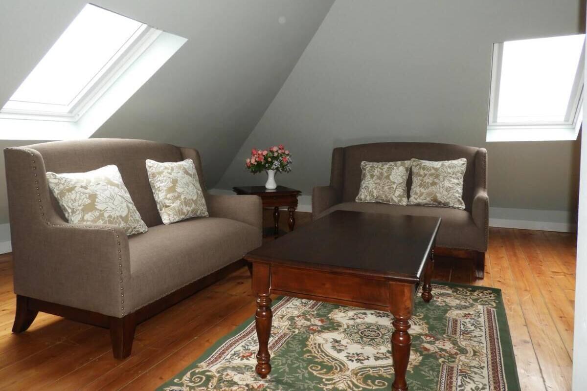 A loft-style room with two sofas, a coffee table, and a floral rug.