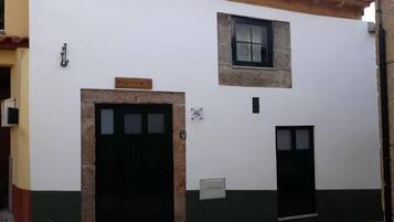 A building with a large black door, a smaller door, and a window. There is a sign above the large door that reads "Refugio D'Anita."