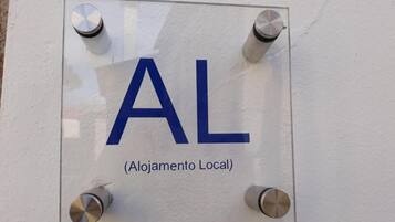 A sign with the letters "AL" and the text "(Alojamento Local)" indicating a local lodging facility.