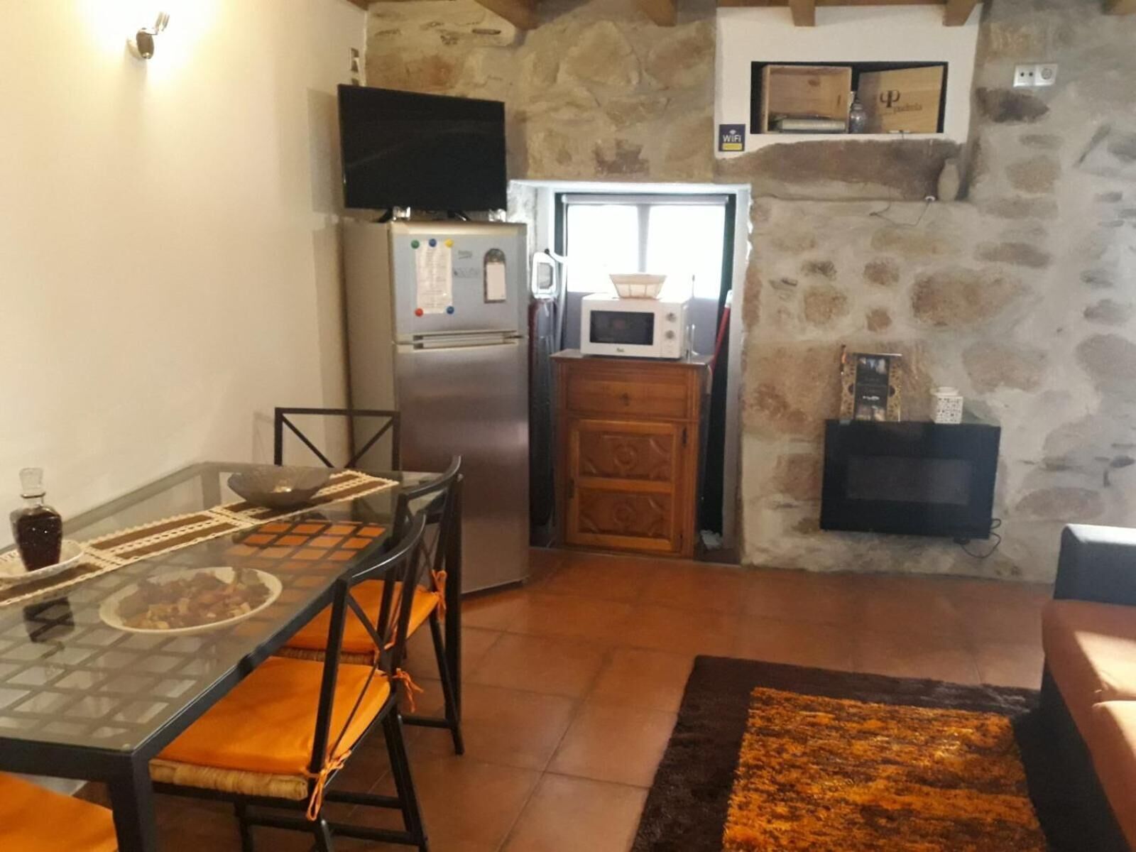 Uma cozinha compacta com geladeira, micro-ondas e um armário de madeira.