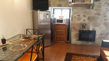 Uma cozinha compacta com geladeira, micro-ondas e um armário de madeira.