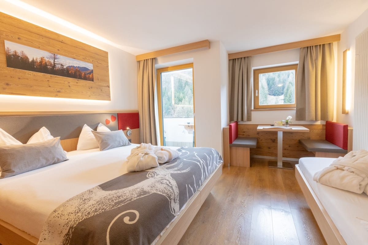 Habitación de hotel moderna con una cama grande, un escritorio y vistas al exterior.