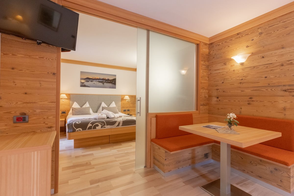 Una habitación moderna con una cama, un banco, una mesa y un televisor.