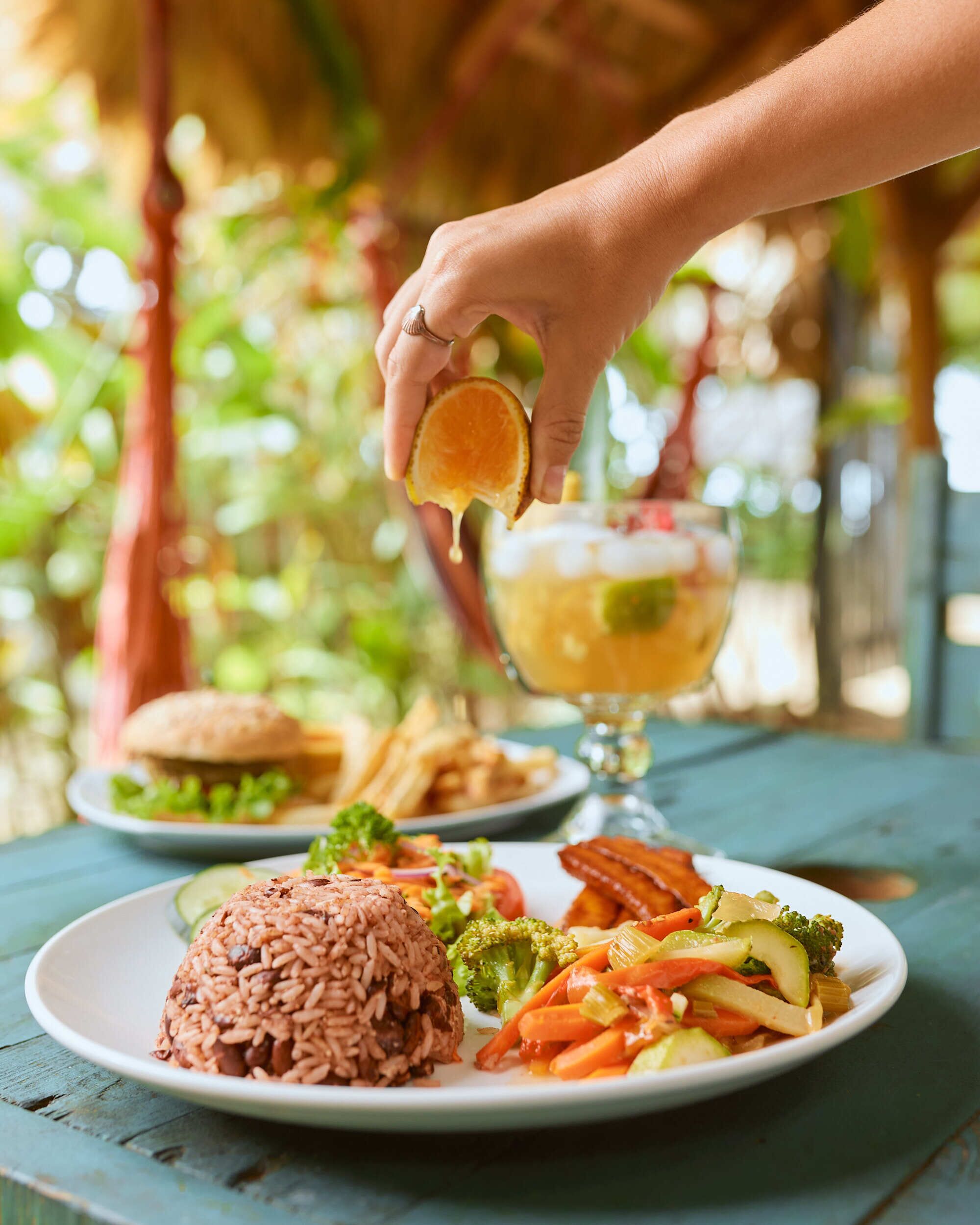 A plate of food with rice, vegetables, and a glass of drink.