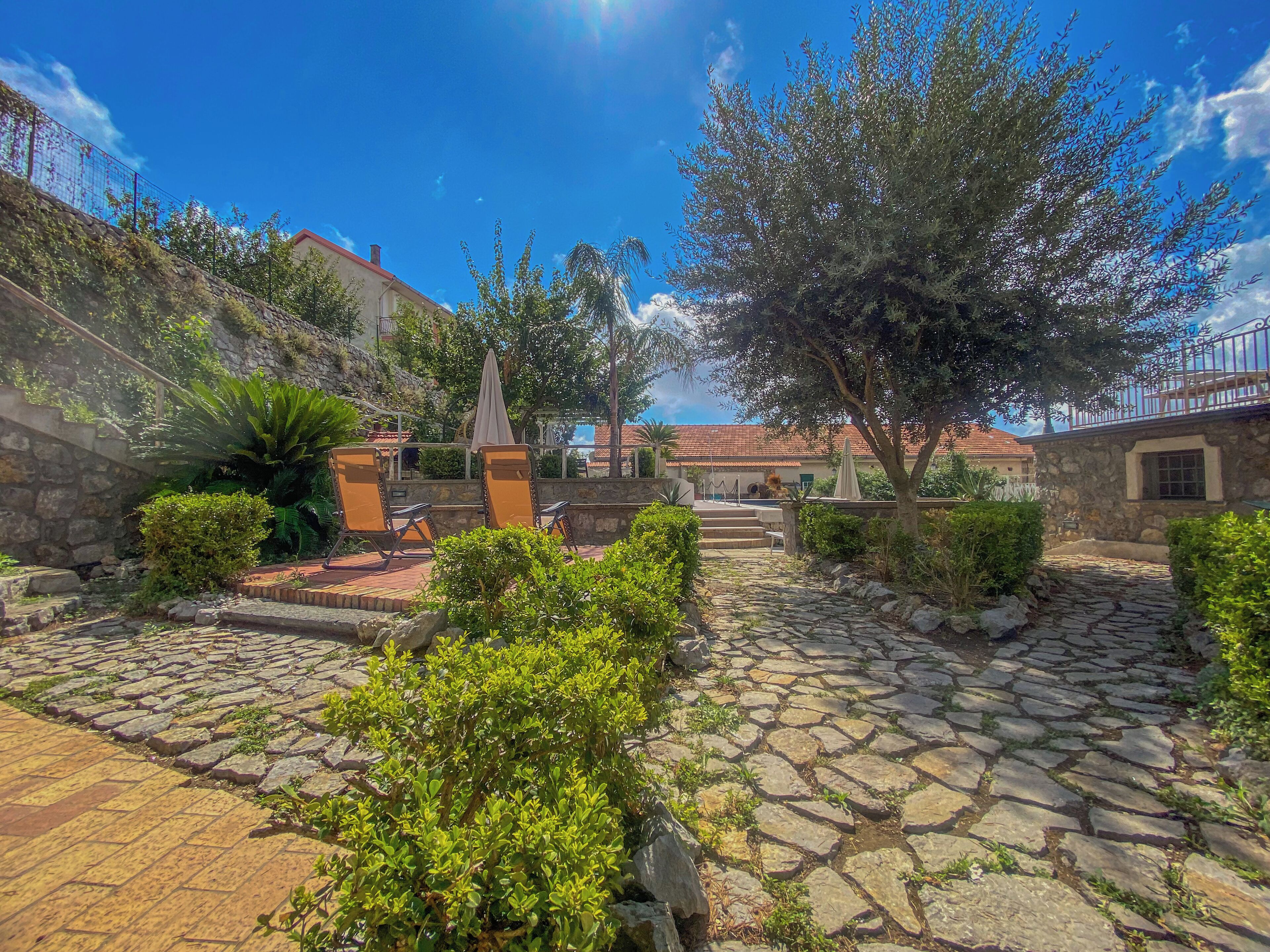Un patio con pavimento de piedra, mobiliario exterior y vistas a edificios al fondo.