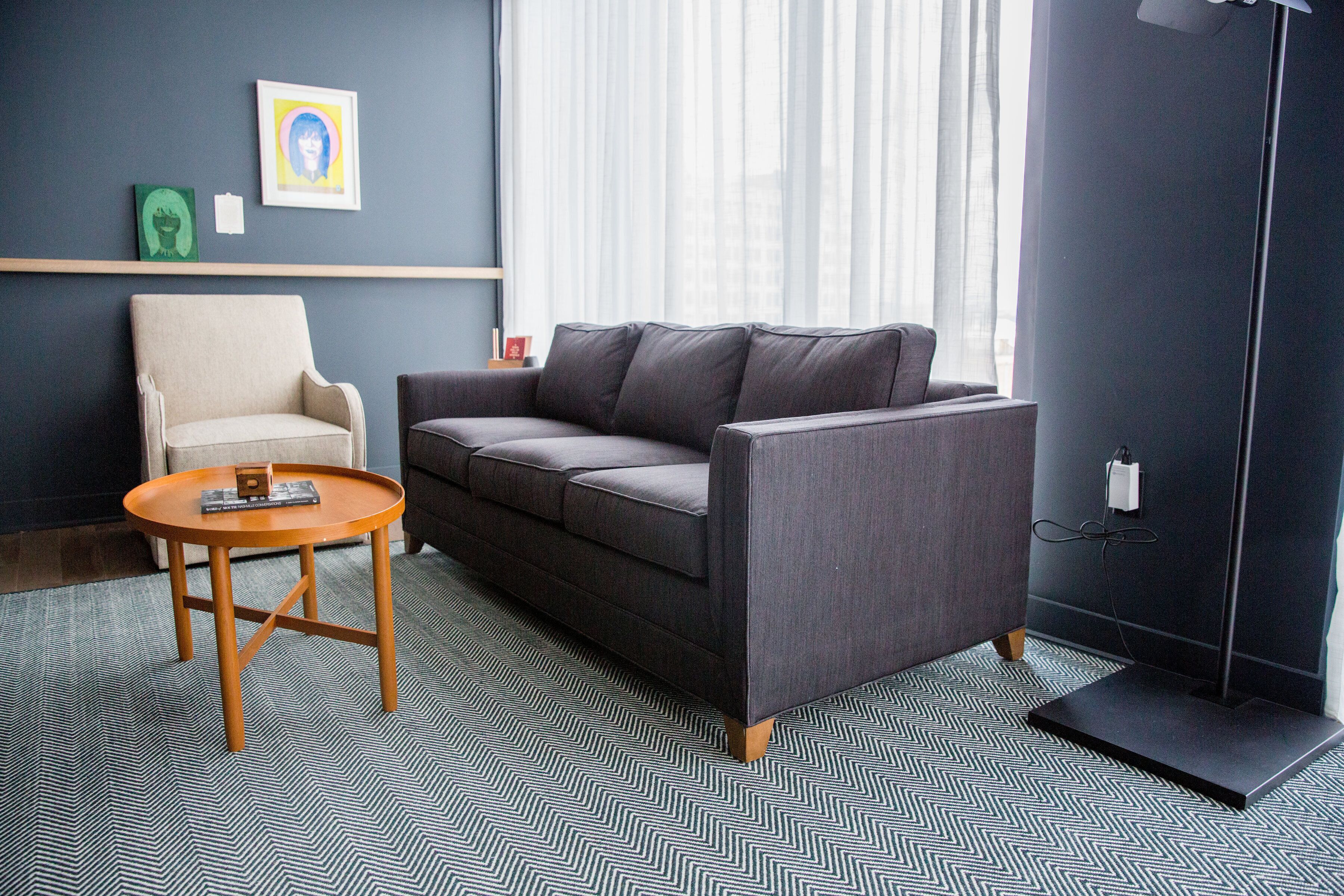 Una sala de estar moderna con un sofá, un sillón y una mesa de centro.
