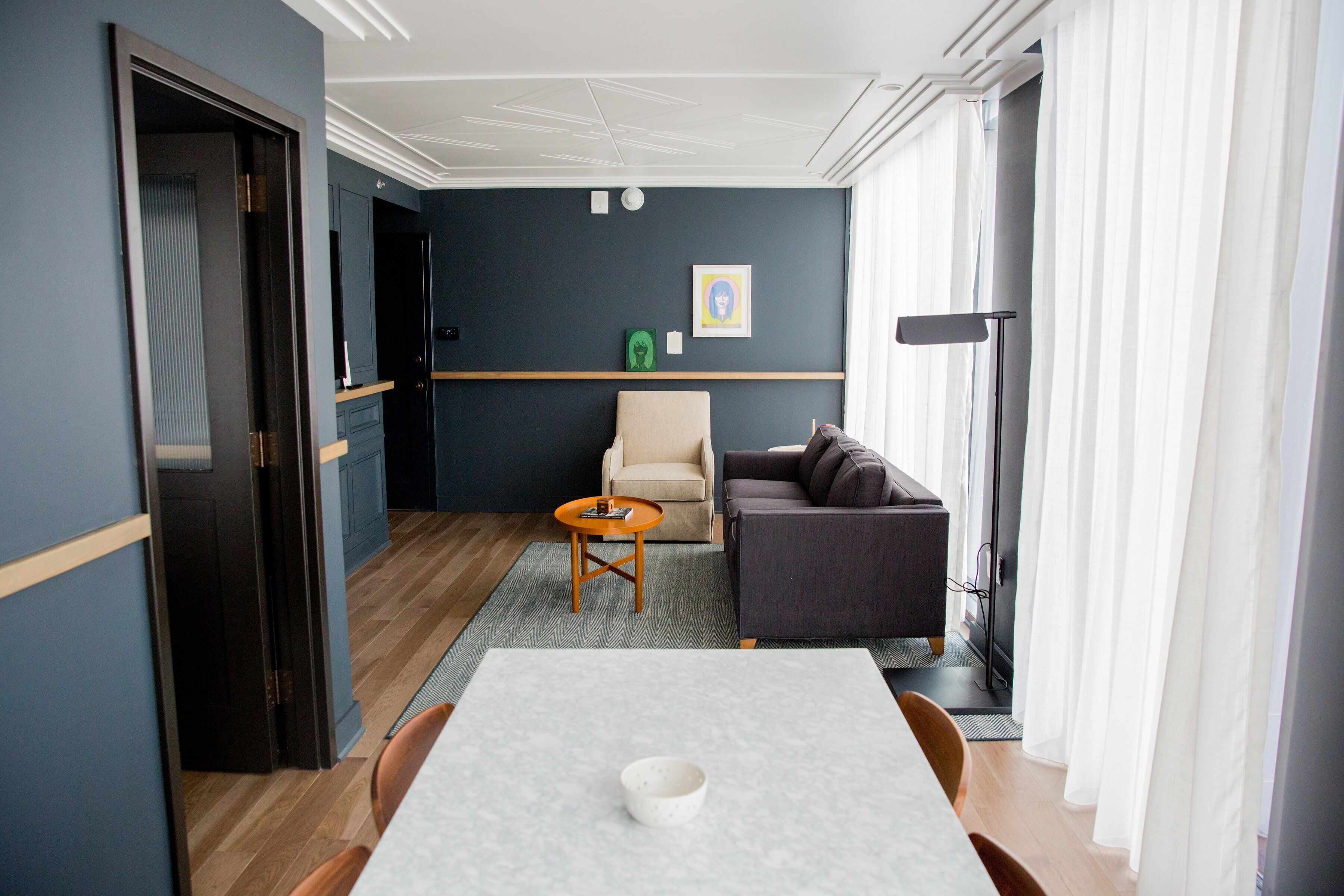 Una sala de estar moderna con una mesa de comedor, un sofá, una silla y una pequeña mesa de centro.
