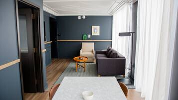 Una sala de estar moderna con una mesa de comedor, un sofá, una silla y una pequeña mesa de centro.