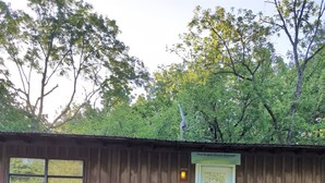 A wooden building with a sign reading "Sugar Creek Retreat" and a staircase leading to a door. - Sugar Creek Retreat (Garfield)
